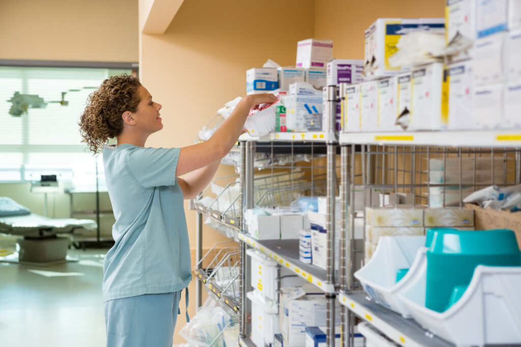 Side view of female nurse working in storage room of hospital